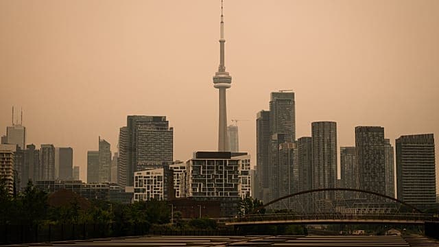 À Toronto, la fumée des feux de forêt canadiennes teinte le ciel d’orange